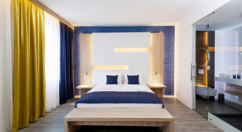 a bedroom with a large bed and a large window, KViHotel Budapest in Budapest