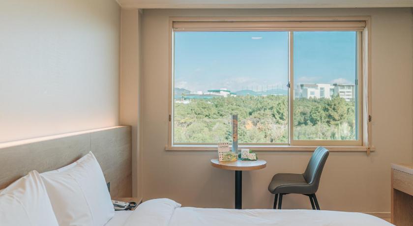a room with a bed, chair and window, Bloom Hotel in Jeju