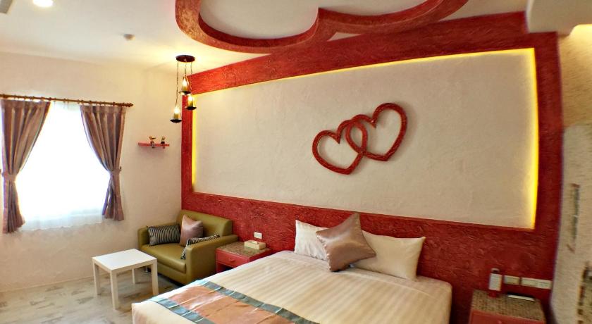 a hotel room with a bed and a dresser, Sin Sin Hotel III in Kenting