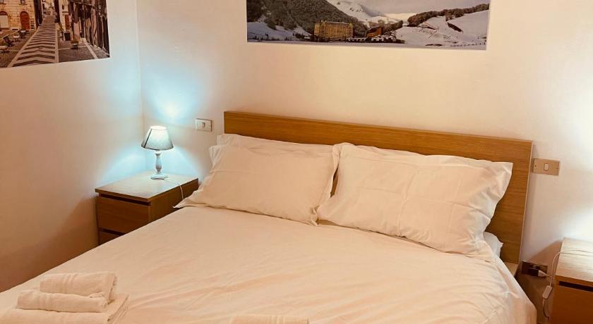 a hotel room with a white bed and white walls, Berga Chalet Pescocostanzo in Pescocostanzo