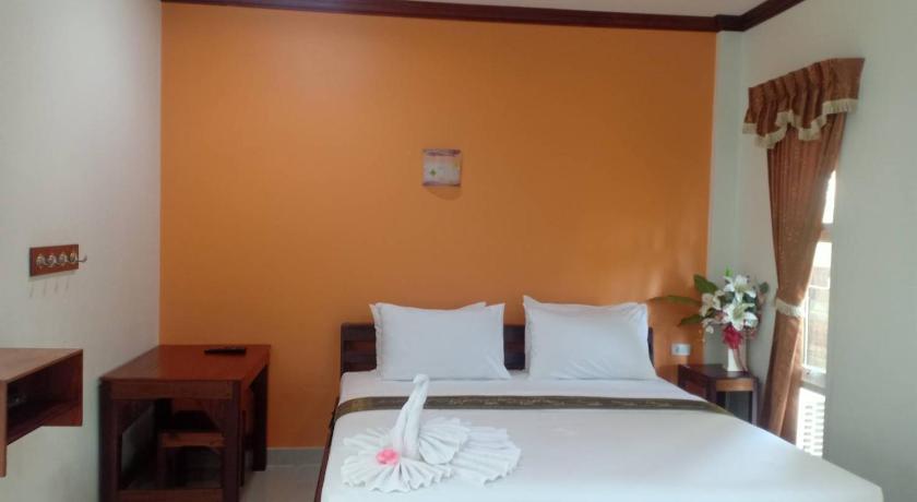 a hotel room with a bed, desk and a lamp, Capital O 75415 Nanthachart Riverview Resort in Samut Songkhram