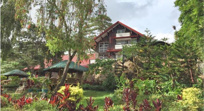 a large garden with trees and a house, Log Cabin Hotel in Baguio