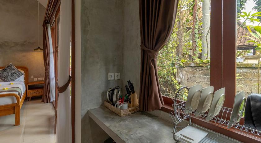 a room with a table, chairs, and a window, Yarama Cottages in Bali