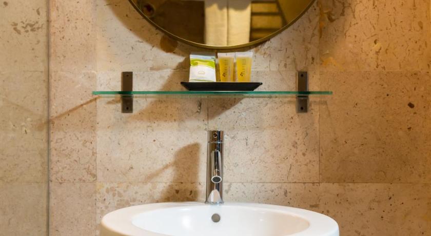 a bathroom with a sink and a mirror, Arck Hotel in Bangkok