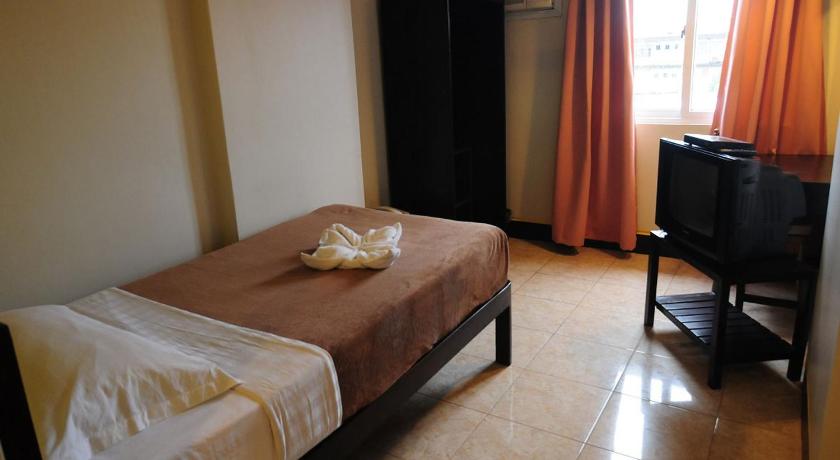 a bedroom with a bed and a dresser, OYO 543 Negrense Suites in Bacolod (Negros Occidental)