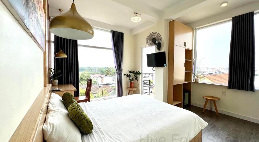 a bedroom with a large bed and a large window, Hue Four Seasons Hotel in Hue