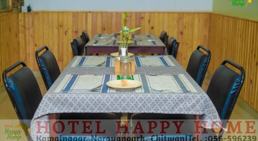 a dining room table with two chairs and a table cloth, Hotel Happy Home in Chitwan