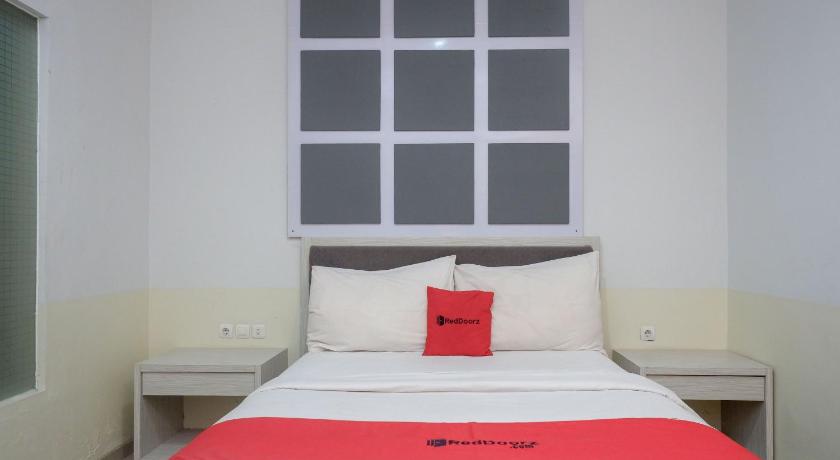 a bed that has a red blanket on it, RedDoorz near Jogja City Mall in Yogyakarta