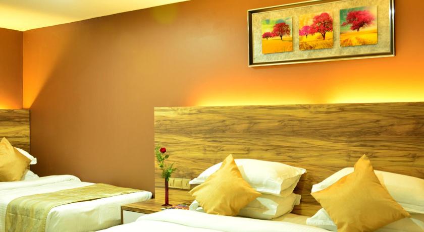 a hotel room with two beds and a painting on the wall, Pearl City Hotel in Colombo