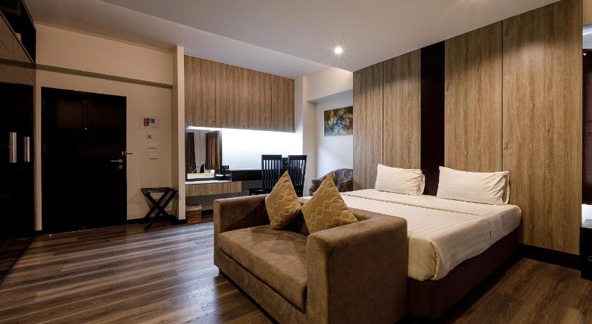 a hotel room with two beds and a television, Grand Marina Hotel in Chonburi