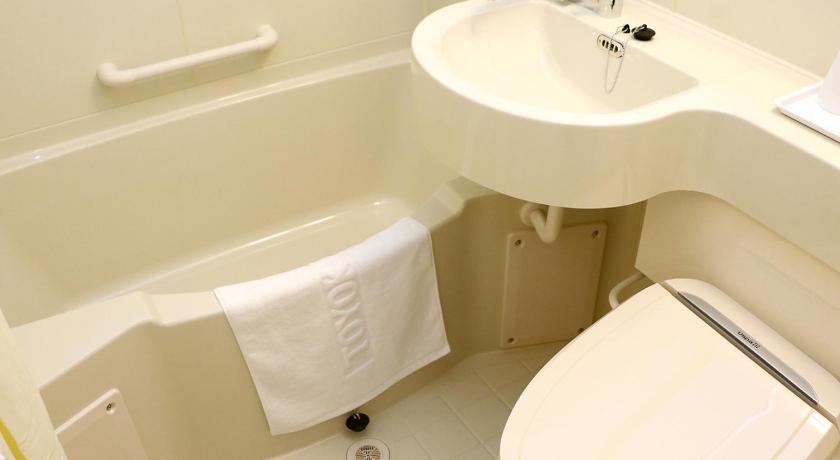 a white toilet sitting next to a sink in a bathroom, Toyoko Inn Shin-Yokohama Ekimae Shinkan in Yokohama