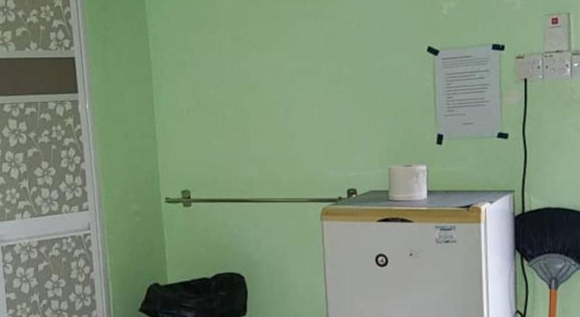a small kitchen with a refrigerator and a microwave, Dhia Irdina Homestay in Mentakab