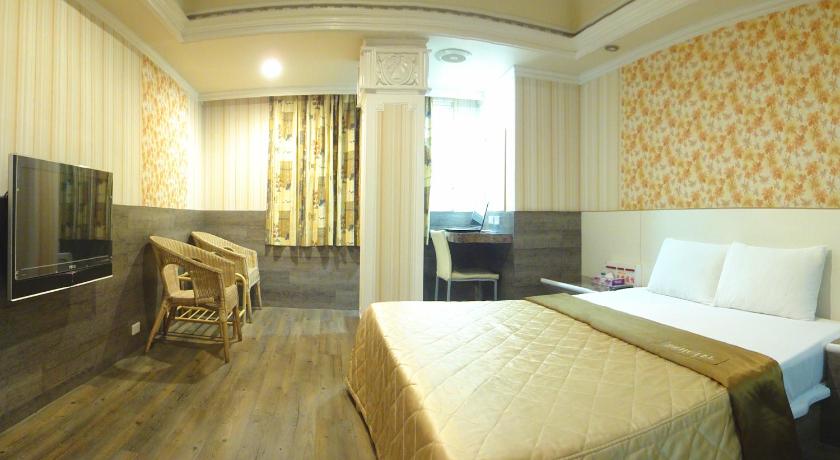 a bedroom with a bed, chair, table and window, Hua Yue Hotel in Taoyuan