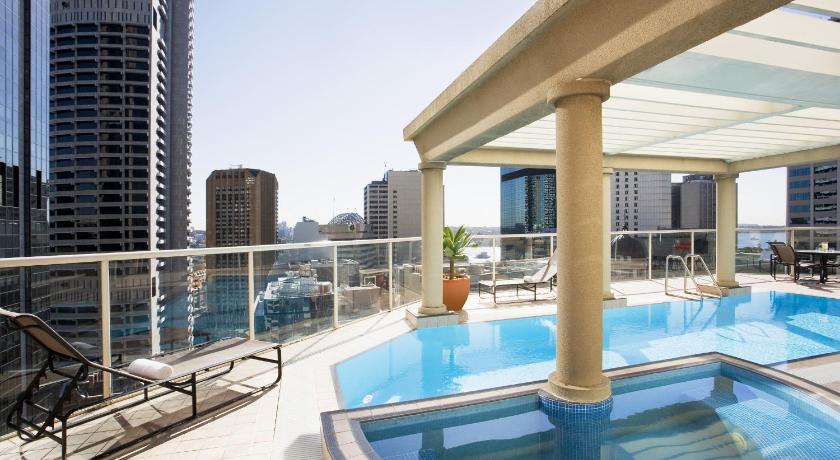 a large swimming pool with a balcony overlooking a city, Mantra 2 Bond Street Sydney in Sydney