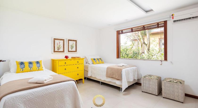 a bedroom with a bed, desk, chair and window, Linda e completa - Casa 150 m da praia, 4 suites in Buzios