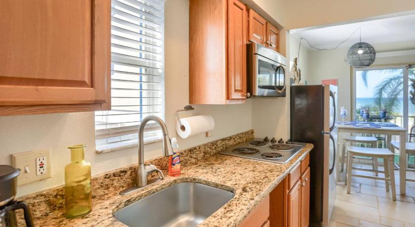 a kitchen with a sink, stove, and refrigerator, 201 Belleair Beach Club in Belleair Beach (FL)