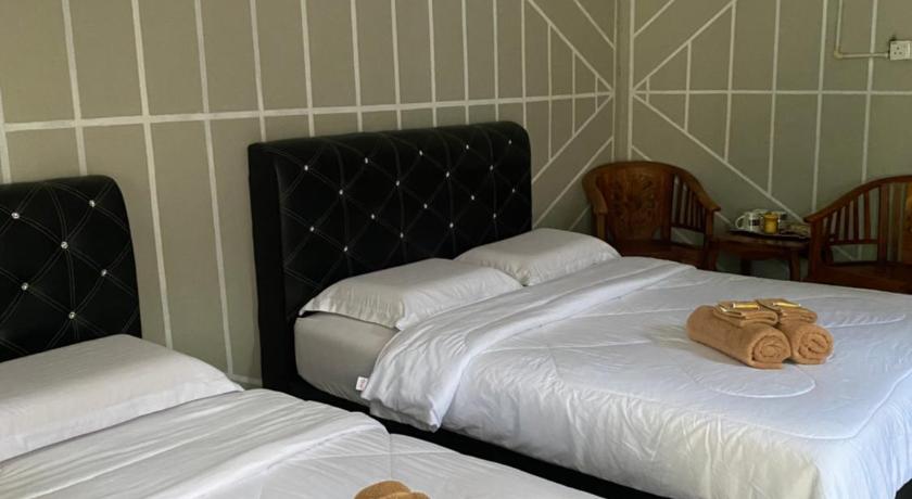 a hotel room with two beds and two lamps, Julies Hostel Taman Negara in Kuala Tahan