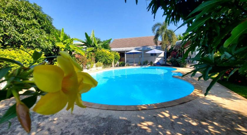 a pool with a yellow umbrella in the middle of it, Nuch's Apple Guest House in Nong Bua Lam Phu