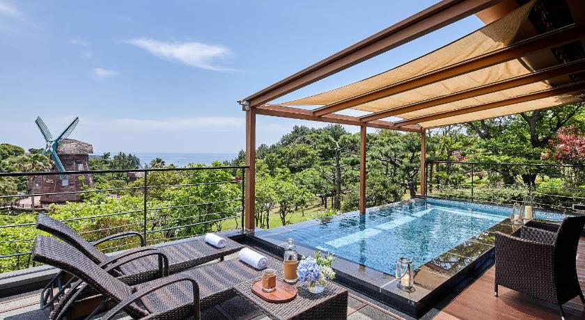a swimming pool with a balcony overlooking the ocean, Lotte Hotel Jeju in Jeju