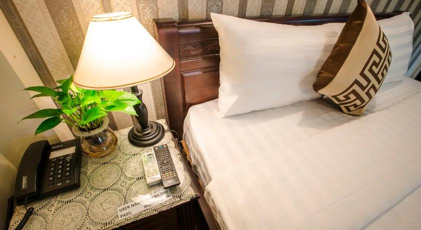 a bed with pillows and a lamp on top of it, Thanh Thu Hotel in Ho Chi Minh City
