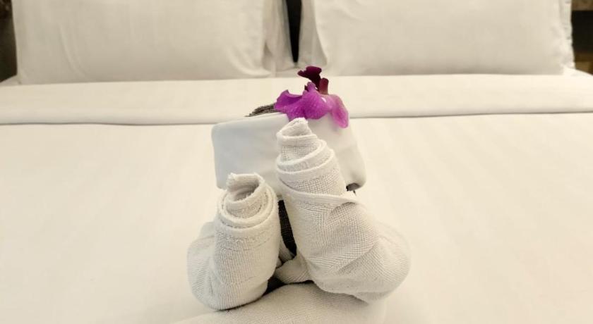 a doll sitting on top of a white pillow on top of a bed, Grand Orchardz Hotel Kemayoran in Jakarta