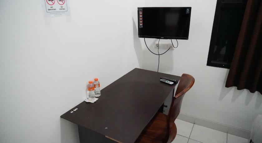 a small tv sitting on top of a wooden table, Casa Feby Guest House in Bandung