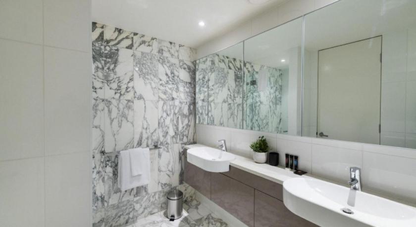 a bathroom with a sink, mirror, and bathtub, Accommodate Canberra - Lakefront in Canberra