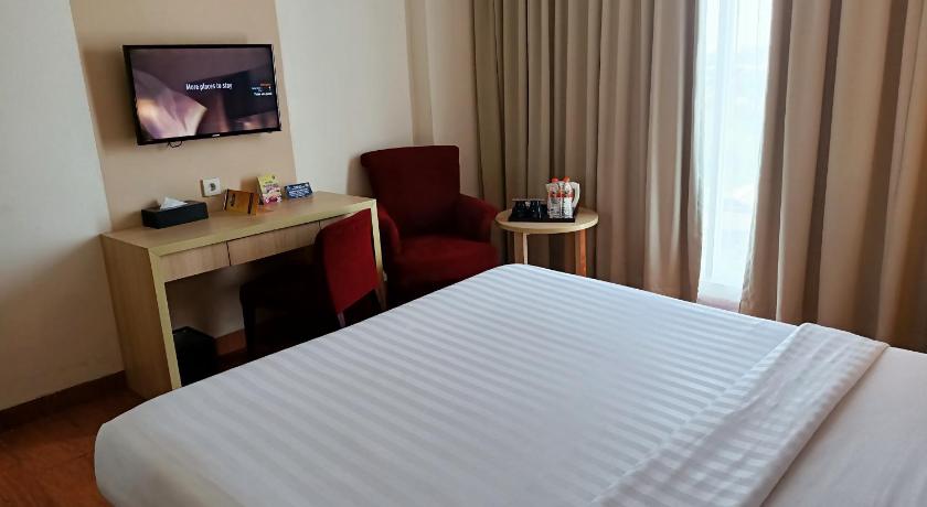 a hotel room with a bed and a television, Days Hotel and Suites Jakarta Airport in Jakarta