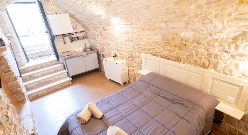 a bedroom with a bed and a wall mounted wall mounted wall mounted wall mounted, Piccola Pietra Bianca in Giovinazzo