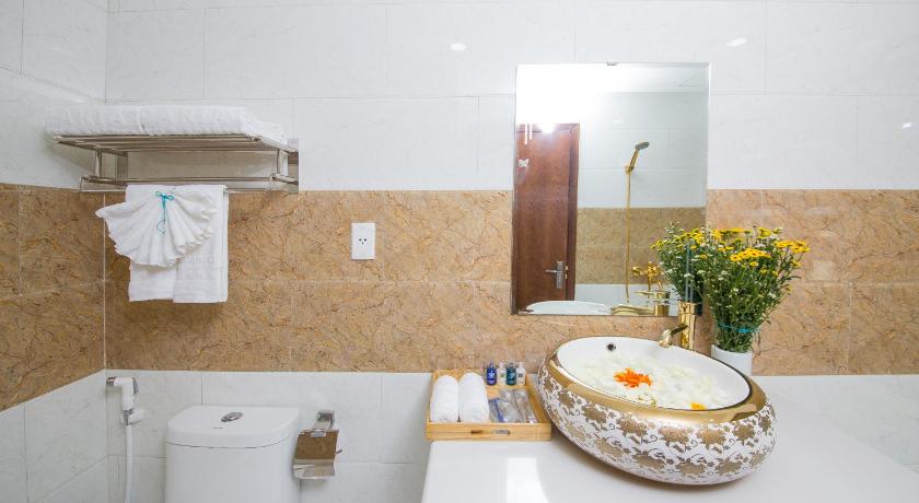 a white toilet sitting next to a sink in a bathroom, Pariat River Front Hotel Da Nang in Da Nang