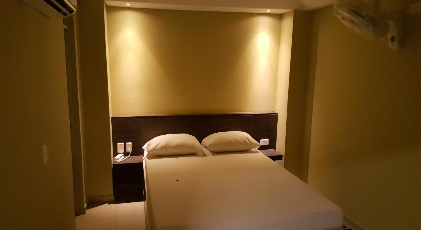 a hotel room with a bed and two lamps, Hotel 56 Avenue Plaza in Barranquilla