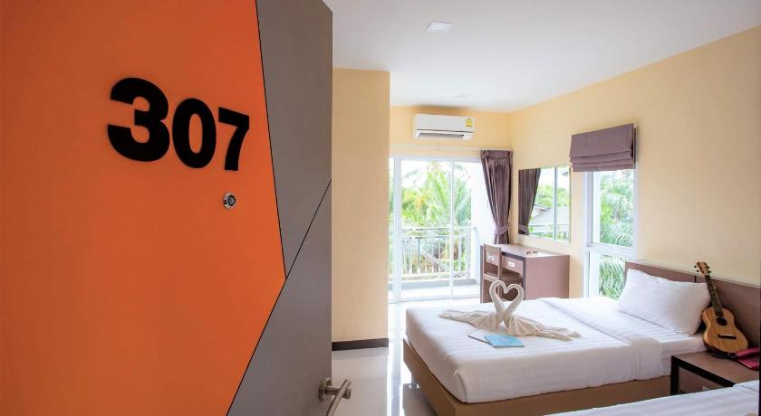 a hotel room with a bed and a mirror, ตะวันอพาร์ทเม้นท์โอเทลThawanapartmentHotel in Satun