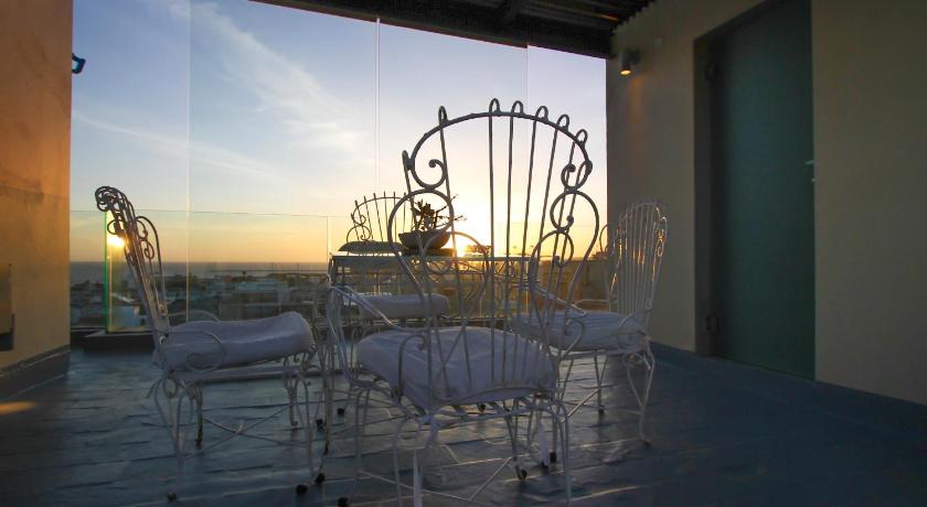 a dining room with chairs, tables, and umbrellas, Alma Historica Boutique Hotel in Montevideo