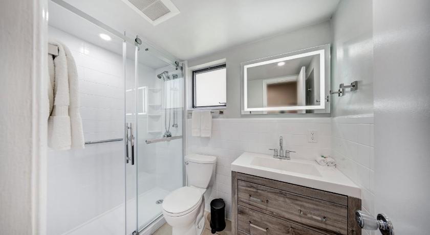 a bathroom with a sink, mirror, and bathtub, Ocean Villas of Deerfield in Deerfield Beach (FL)