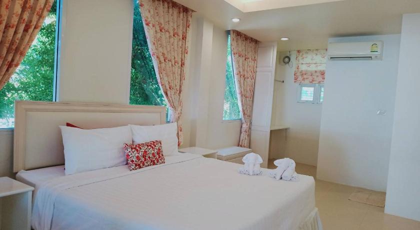 a hotel room with two beds and a table, Banlomnow Hotel in Chiang Rai