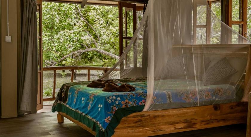 a bed that has a canopy over it, Monkey Mansion Bungalows in Khao Sok (Suratthani)