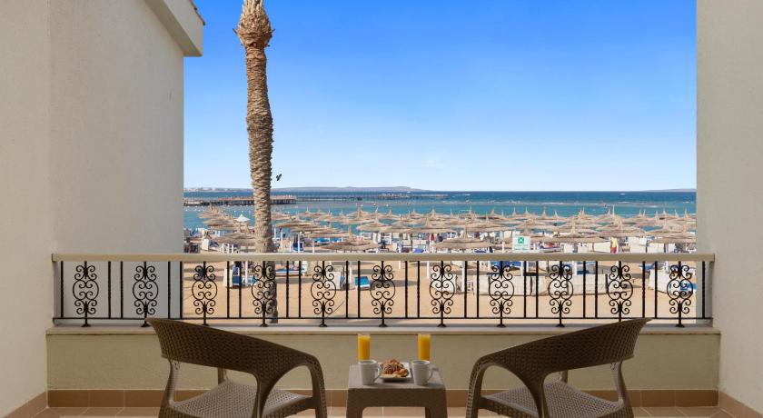 a dining room table with chairs and a balcony overlooking the ocean, Pickalbatros Dana Beach Resort - Hurghada in Hurghada