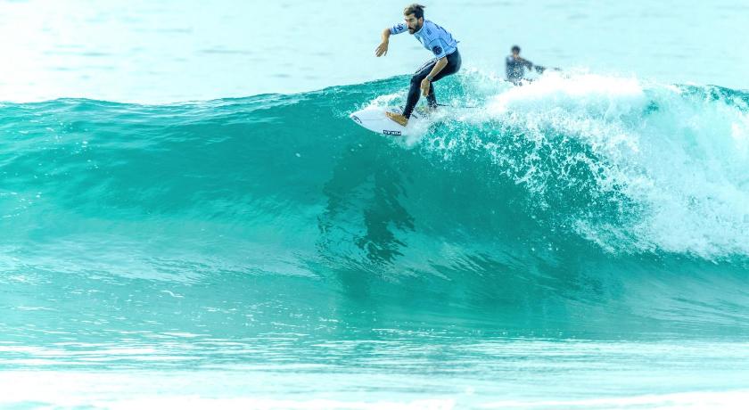 a man riding a wave on top of a surfboard, Destination Resort Phuket Karon Beach (SHA Plus+) in Phuket