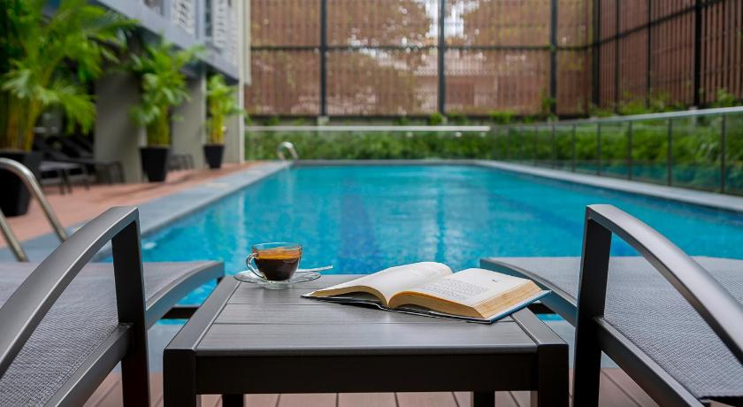 a book is sitting on a table near a pool, SILA Urban Living in Ho Chi Minh City