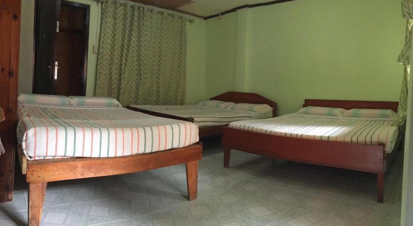 two beds in a room with a wooden floor, UYAMI'S GREENVIEW LODGE AND RESTAURANT in Banaue