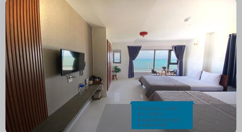 a hotel room with a bed, tv and a balcony, Thien Hai 2 Hotel in Quy Nhon (Binh Dinh)