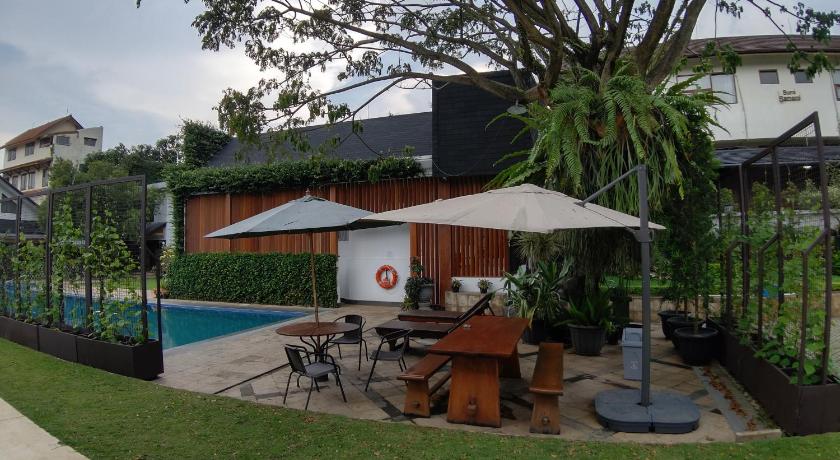 a patio area with a table, chairs, and a patio umbrella, Samami Garden in Bandung