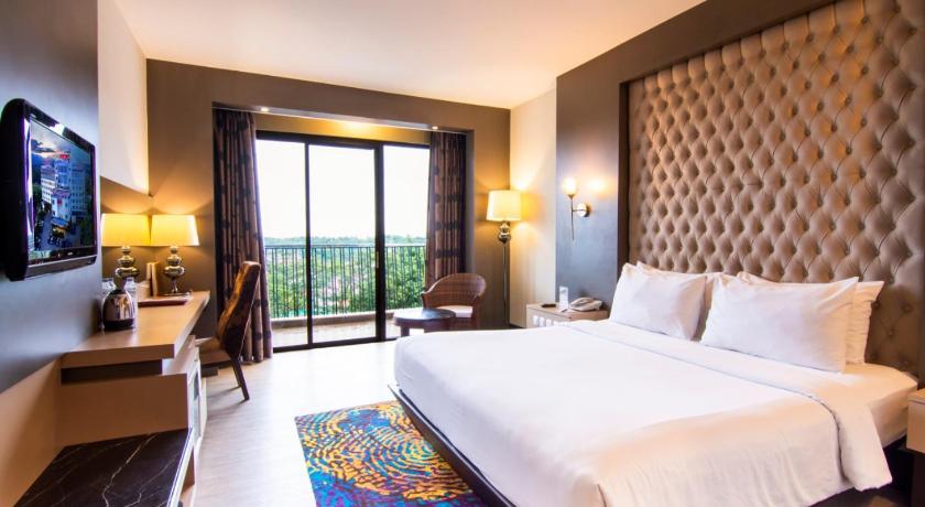 a hotel room with two beds and a television, Grand Rocky Hotel Bukittinggi in Bukittinggi