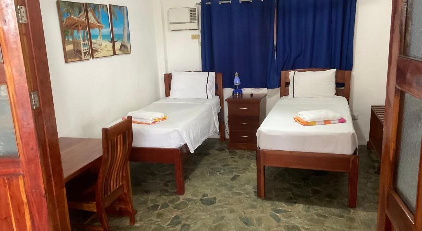 a bedroom with two beds and a desk, Rainbow Bay Beach & Dive Resort in Siquijor Island