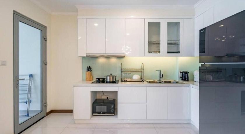 a kitchen with white cabinets and white appliances, Bland Landmark Plus Luxury Residence in Ho Chi Minh City