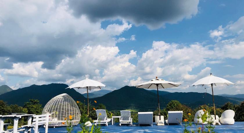 a patio area with umbrellas and chairs, E-outfitting Pai Resort in Pai