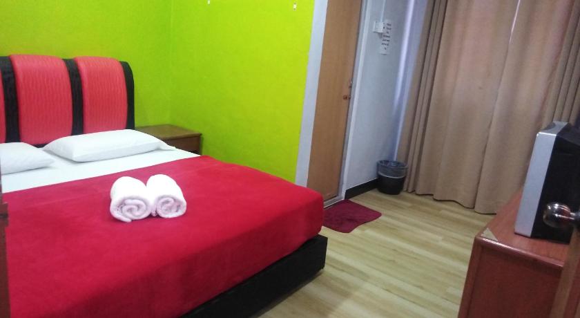 a bedroom with a bed and a dresser, Samudera Hotel in Besut