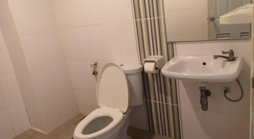 a white toilet sitting next to a sink in a bathroom, Capital O 75415 Nanthachart Riverview Resort in Samut Songkhram