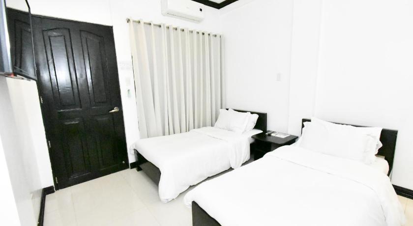 a hotel room with a white bed and white walls, Swiftlets Inn in Palawan