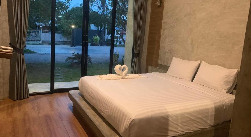 a white bed sitting in front of a window, Alinda Resort Phetchaburi in Phetchaburi